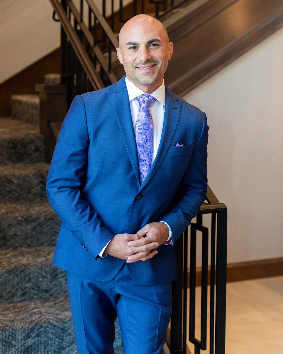 Dr. Castel Santana in a blue suit on the staircase at Evoke 5