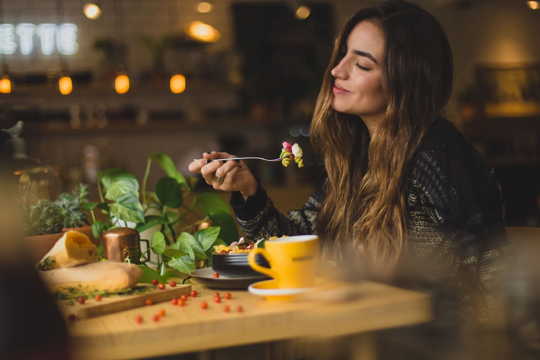 A woman enjoying a meal at a warmly lit restaurant